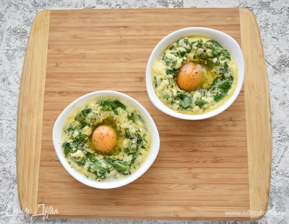 Достаю формы из духовки, ложкой делаю в центре углубление и вбиваю в каждое по одному яйцу, стараясь не повредить желток. Сверху посыпаю солью и черным молотым перцем. Снова запекаю в духовке (уже без фольги, чтобы белок схватился, а желток остался жидким).