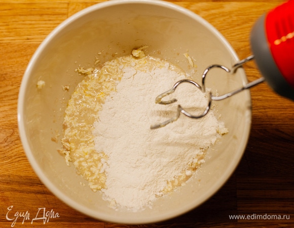 Замесить тесто, постепенно подсыпая муку. Когда тесто возьмет достаточно муки, оно станет эластичным и не будет липнуть к рукам.