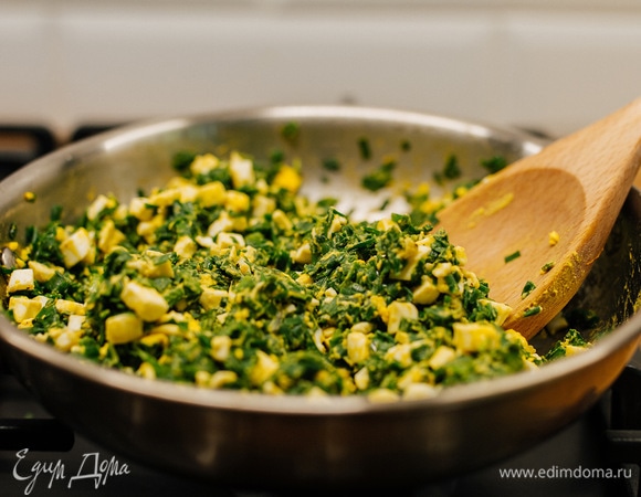 Добавить яйца к луку, посолить и поперчить. Перемешать.