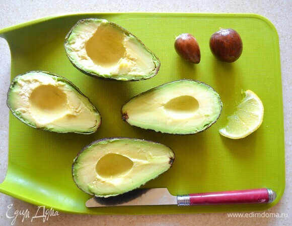 Авокадо помойте, разрежьте пополам и выньте косточку. С помощью ложки аккуратно выньте мякоть, не повредив кожицу. Получившиеся лодочки послужат природными тарелочками для подачи салата. Мякоть переложите в миску, разомните и сбрызните лимонным соком. Добавьте дижонскую горчицу, приправьте солью.