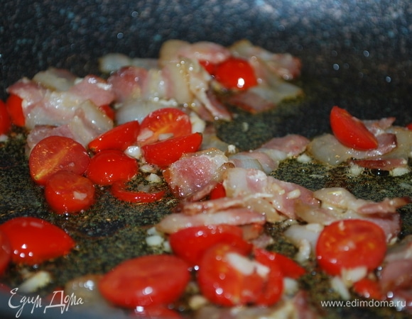 Сковороду с толстым дном хорошо разогрейте, налейте оливковое масло и обжарьте мелко нарезанный бекон. Помидоры черри разрежьте пополам, чеснок и острый перец мелко порубите (острый перец регулируйте по вкусу, у меня мелкий и не очень острый перец). Выложите к бекону помидоры с чесноком и немного прогрейте.