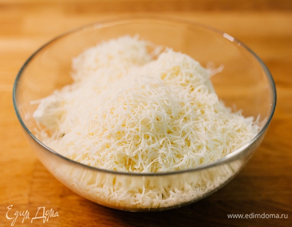 Добавить к шпинату рикотту и тертые моцареллу и пармезан.