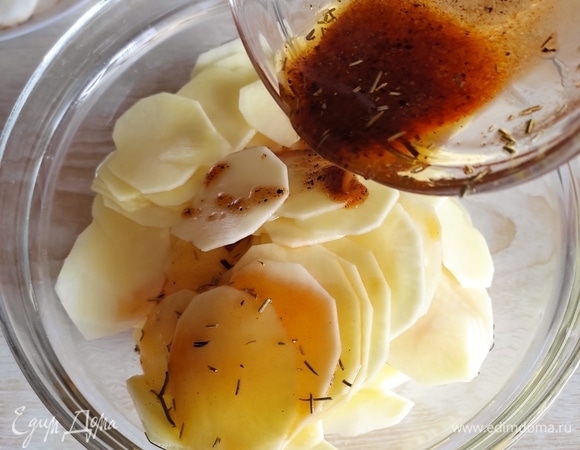 Половиной смеси масла и специй полить картошку, аккуратно перемешать, чтобы масло покрыло все слайсы.