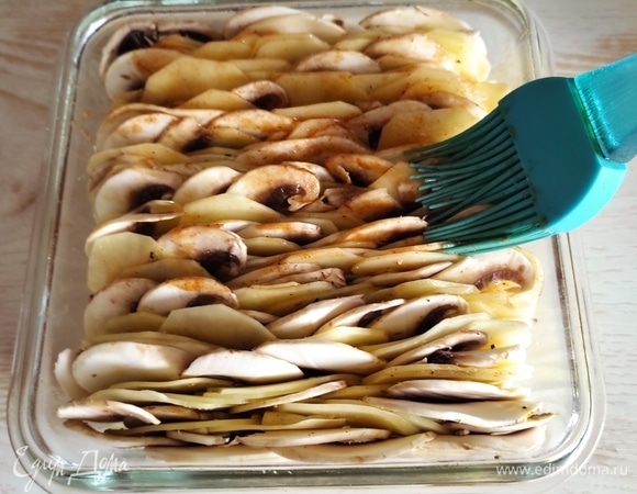 Второй половиной масла со специями смазать верх. Накрыть фольгой и запекать в духовке, разогретой до 180°C, до готовности. В среднем это занимает около 1 часа (зависит от размера формы).