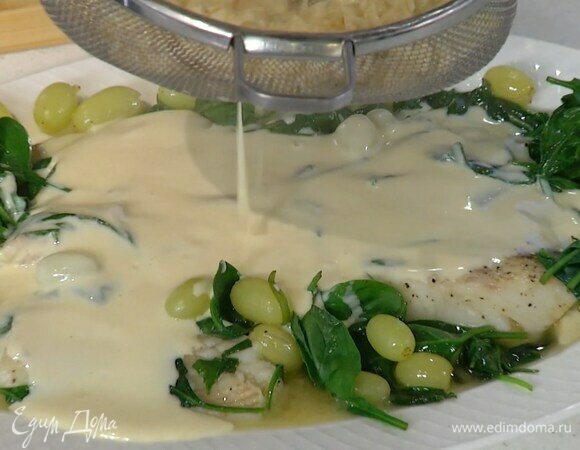 Палтуса со шпинатом и виноградом переложить в тарелку и через сито залить сливочным соусом.