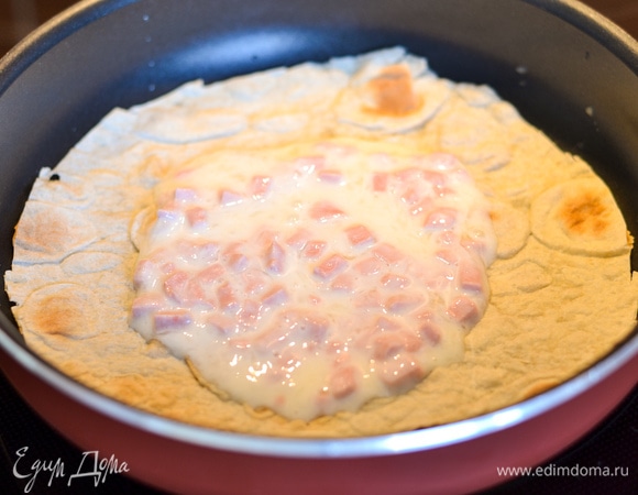 Кладем круг из лаваша по размеру сковороды. Выкладываем в центр белковую массу.