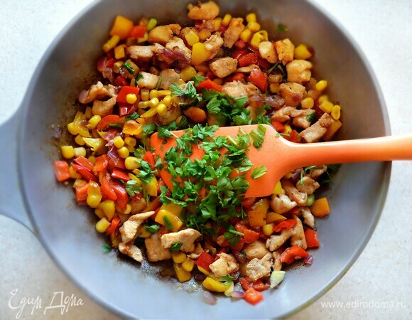 В самом конце приготовления добавьте в сковороду мелко нарезанный зеленый лук, петрушку и кукурузу.