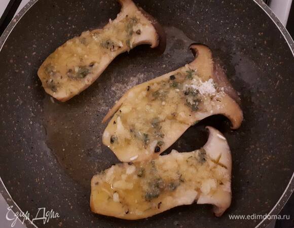 Выложите по 1 ч. ложке чесночного масла на еринги и жарьте еще 30 секунд.