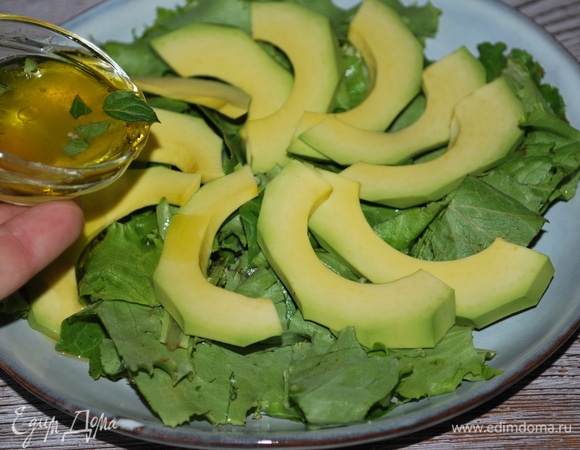 Приготовьте заправку для салата, перемешав оливковое масло, сок лимона и жидкий мед. Свежую мяту мелко нарежьте и добавьте к заправке. Полейте салатные листья и авокадо.