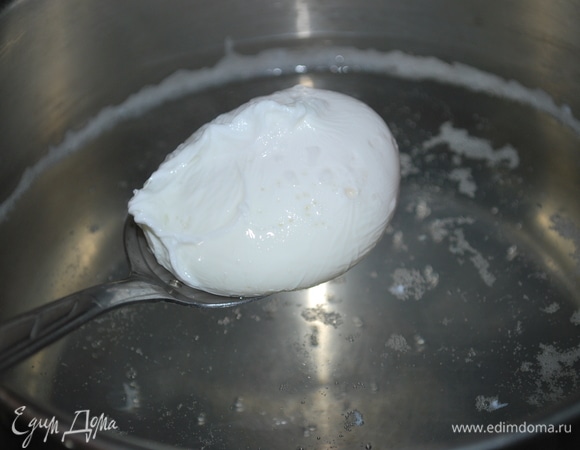 В небольшое количество кипящей воды налейте немного уксуса и аккуратно вылейте яйцо. Убавьте огонь и варите около 2 минут, затем шумовкой достаньте яйцо и выложите на салат. Сварите второе яйцо.