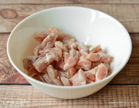 Свинину нарезать тонкими полосками и обвалять в муке.