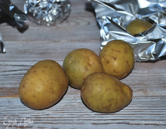 Картофель оберните фольгой и запеките в духовке при 180°C примерно около часа.