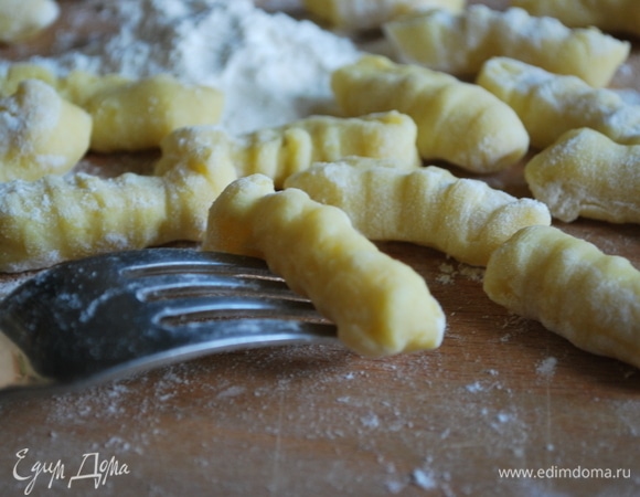 От готового теста отщипывайте небольшие кусочки и раскатывайте колбаски. Прижмите кусочки теста к зубцам вилки, чтобы ньокки стали рифлеными. Таким образом из всего теста сделайте рифленые ньокки.