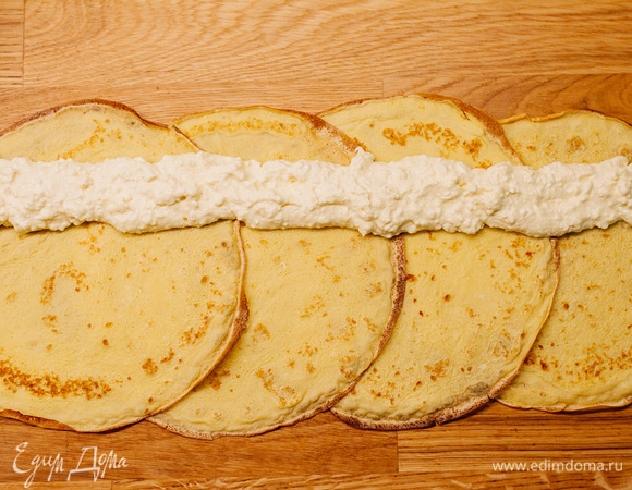 С одного края выложить полосу творожной начинки по всей длине.