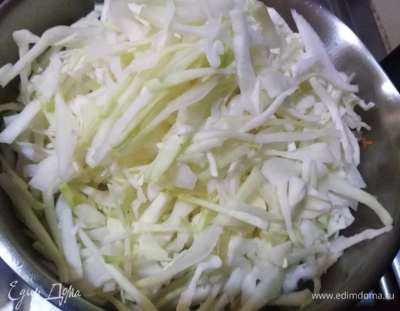 Добавляем нашинкованную капусту, солим. Накрываем крышкой и тушим на тихом огне 2 часа, помешивая.