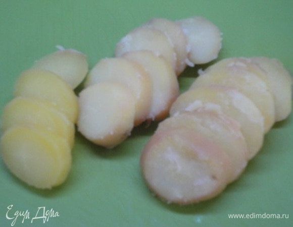 Сваренный в соленой воде картофель в мундире очистить и нарезать кружочками. Лук нарезать тонкими кольцами или полукольцами.