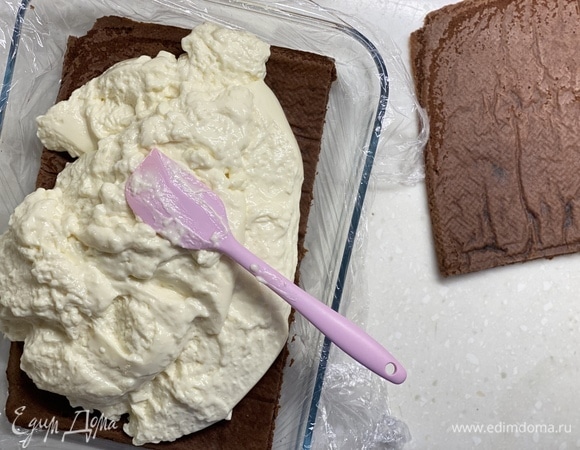 Собрать десерт в подходящей форме. Корж разделить на 2 части. Поместить на дно формы корж, затем — все суфле. И сверху — второй корж. Убрать в холодильник на 2 часа или на ночь.