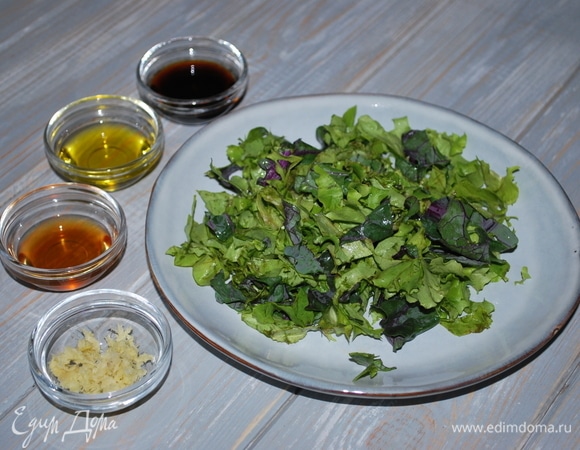 Салатный микс вымойте, нарежьте и выложите на тарелку. Имбирь почистите, натрите на мелкой терке (у меня 1 чайная ложка). Приготовьте заправку для салата: кунжутное, ореховое масло, имбирь, соевый соус и 1 столовую ложку лимонного сока соедините вместе и перемешайте.