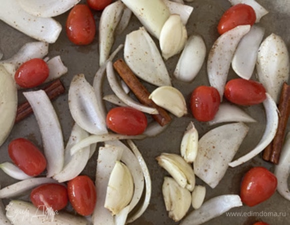 В противень или другую посуду для запекания выкладываем помидоры, головку очищенного чеснока, лук-шалот, нарезанный на 4 части, 3 палочки корицы, кориандр. Поливаем оливковым маслом, перемешиваем хорошенько и отправляем запекаться в духовку на 40–45 минут при 160°C. На фото белый лук, но нужен именно шалот красный. Так вкуснее.