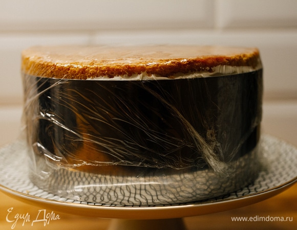 Сверху выложить второй бисквит и повторить то же самое. Затем накрыть третьим бисквитом, обернуть форму пищевой пленкой и убрать в холодильник на 5–8 часов.