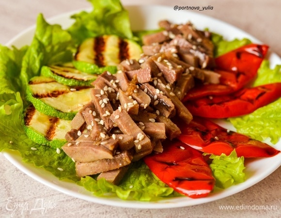 На блюдо кладем листья салата. Выкладываем теплые овощи с гриля. Язык (я его чуть подогрела) смешиваем с половиной заправки и кладем к овощам. Поливаем салат остатками заправки. Посыпаем кунжутом. Приятного аппетита!