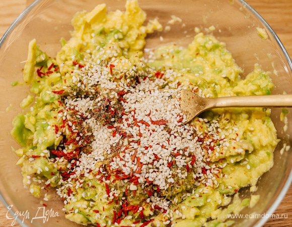 Добавить кунжут, травы, соль, перец. Перемешать.