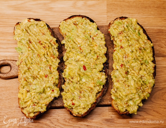 Хлеб поджарить в тостере или на сухой сковороде. Выложить на хлеб массу из авокадо.