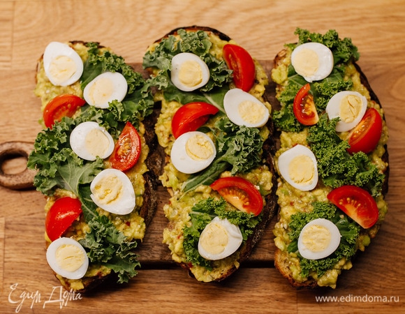 Сверху положить листы кейла или любую другую листовую зелень. Затем — перепелиные яйца, разрезанные пополам, и помидоры черри.