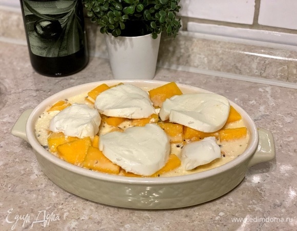 Форму для запекания смажьте растительным маслом, выложите тыкву и залейте сливочной смесью. Сверху положите кусочки сыра моцарелла.