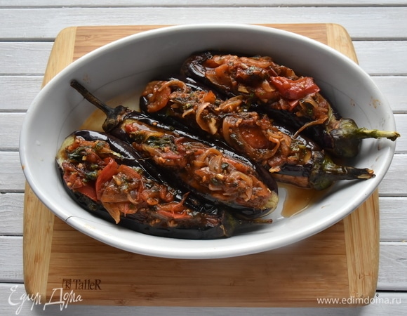 Фарширую обжаренные баклажаны овощной смесью. Если начинки много, ее можно выложить на дно формы для запекания. Укладываю баклажаны в жаропрочную форму и запекаю в духовке, разогретой до 180°C, в течение 15–20 минут.