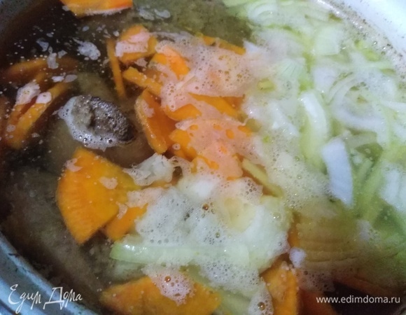 В процессе готовки в кастрюлю добавить нарезанные лук и морковь. Мясо вынуть, отделить от костей. Выложить обратно в бульон.