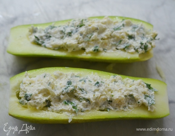 Выложите начинку в кабачки. Запекайте в разогретой до 180°C духовке около 30 минут.