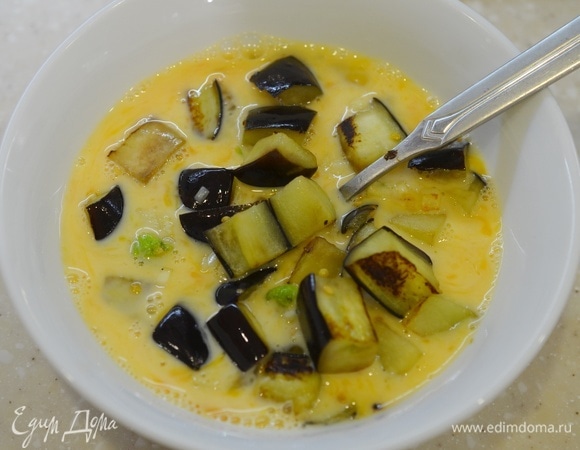 Добавьте в яичную смесь баклажаны с перцем и чесноком.