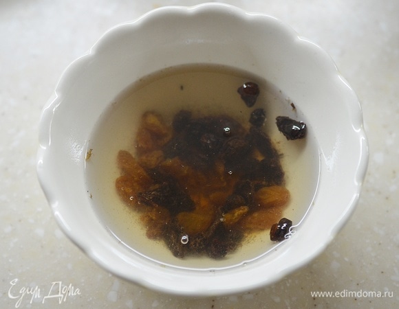 Изюм промойте, залейте кипятком, чтобы он стал мягче. Оставьте минут на 10.