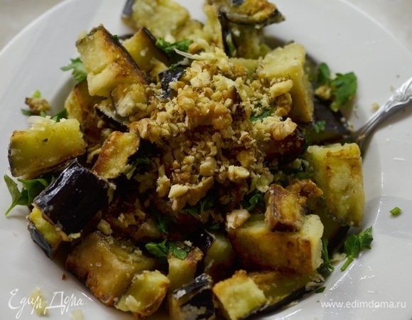 Добавьте в салат орехи и зелень петрушки. Перемешайте.