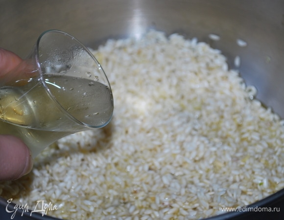 Добавьте белое вино, выпаривайте его в течение 2–3 минут, помешивая.