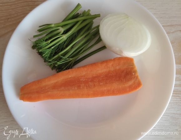 В кастрюлю сложить голову, хвост, плавники и хребет, залить водой, добавить половину луковицы, половину моркови средней величины, стебли свежего укропа и поставить все вариться. После того как бульон будет готов, его нужно процедить и вернуть на плиту.