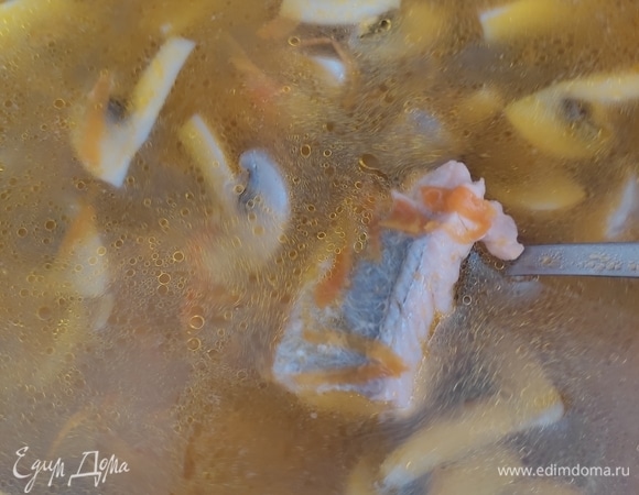 В готовый бульон добавляем картофель, варим до полуготовности. Далее кладем кусочки рыбного филе. После этого добавляем зажарку из лука и моркови, грибы и помидоры. Даем похлебке закипеть и кипятим около 5 минут.