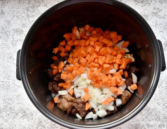 Перекладываю к мясу морковь и лук. Солю, перчу и перемешиваю.