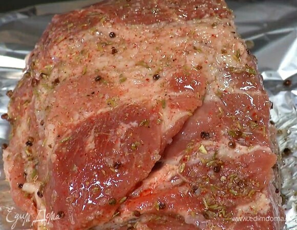 Свиную шейку часто наколоть ножом, так чтобы получились надрезы в сантиметр глубиной, выложить на двойной слой фольги и смазать со всех сторон пряным маслом.