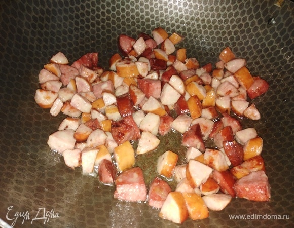 В кастрюлю налить воды, поставить на огонь. На 1 ст. л. растительного масла обжарить колбасу и отправить ее в закипевшую воду.