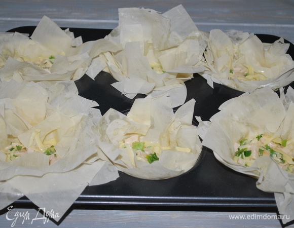 Форму для выпечки смажьте маслом (у меня форма для крупных кексов, 6 шт.) Тесто фило выложите в формы, по 4 листа в каждую форму. Заполните тесто начинкой.