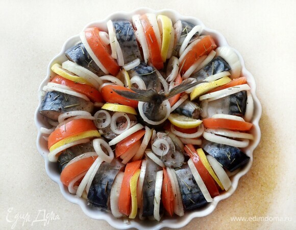 Рыбу, овощи и лимон слегка посолите, приправьте перцем и выложите в жаропрочную форму, смазанную оливковым маслом. Сверху посыпьте розмарином и сбрызните оливковым маслом. Поставьте в разогретую до 190°C духовку примерно на 40 мин. Хвостик рыбы оберните фольгой, чтобы не подгорел.