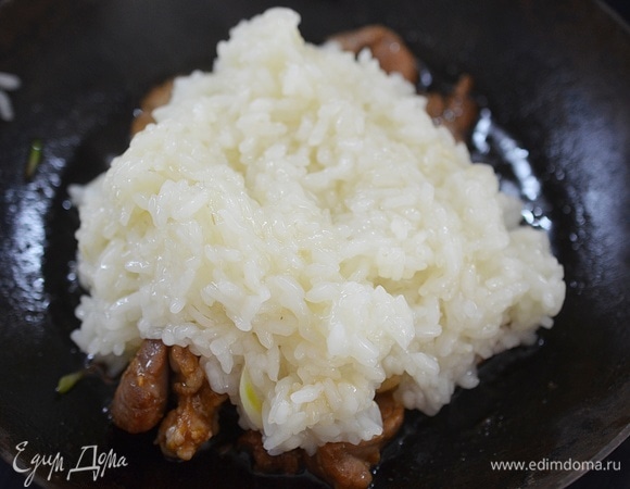В сковороду к мясу добавьте рис.