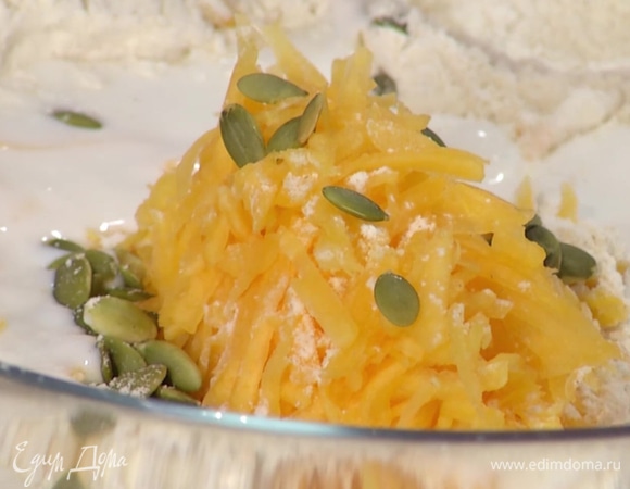 К муке добавить натертую тыкву, тыквенные семечки, кефир и соль, вымешать тесто.