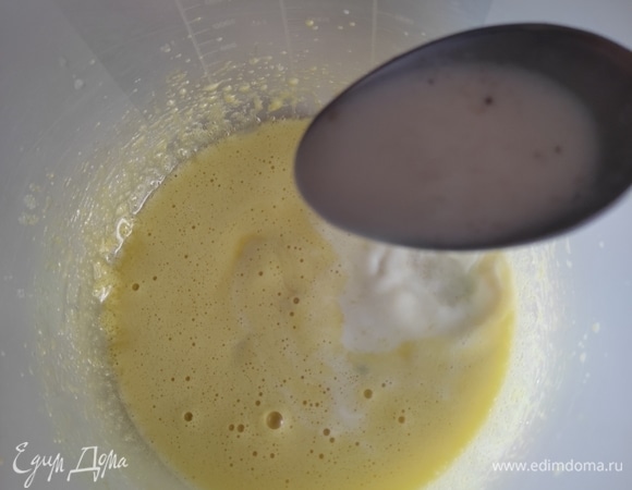 По 1 ст. л. аккуратно вливать горячую молочную смесь в желтки, интенсивно размешивая.