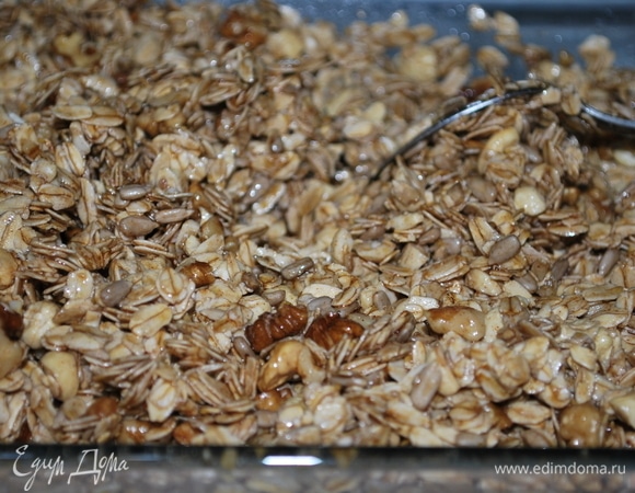 Влейте теплый сироп в овсяные хлопья с орехами, перемешайте.