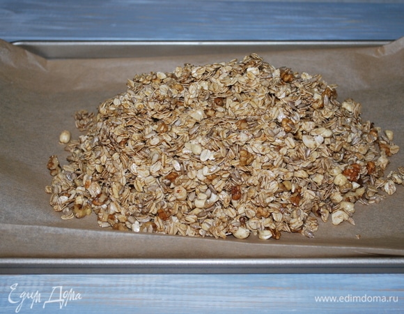 Противень застелите бумагой для выпечки и тонким слоем распределите овсяные хлопья. Запекайте при температуре 170°C примерно 50 мин., постоянно помешивая, чтобы гранола не пригорела.