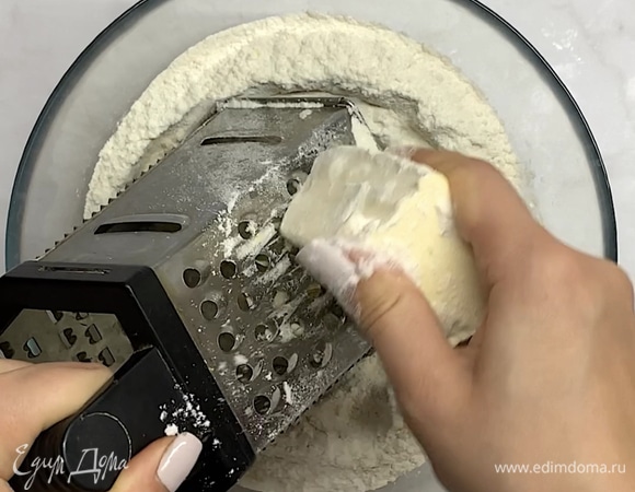Смешиваем 300 г муки и разрыхлитель. 125 г холодного сливочного масла обваливаем в муке и натираем на терке. Периодически обваливаем в муке. Когда все масло натерли, можно перетереть его руками с мукой.