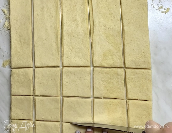 Когда начинка закончилась и мы раскатали тесто для печенья, разрезаем заготовку на небольшие квадратики.